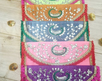 May include: Six colorful embroidered fabric envelopes with a paisley design and fringe trim. The envelopes are stacked on top of each other, with the top envelope being purple, the next being pink, then blue, orange, green, and finally orange.
