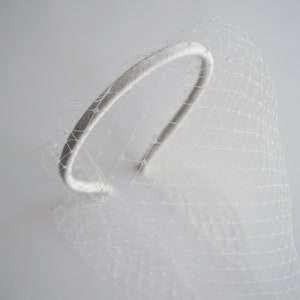 Birdcage blusher veil features with velvet headband and faux pearls. Bridal hairband with pearl bandeau veil is hand made. Bachelorette veil come with a scattering of pearls or without. 
Ivory fascinator headband has been covered with bird cage veil