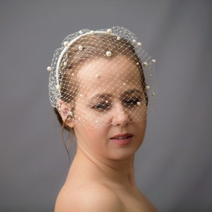 Wedding birdcage veil features with velvet headband and pearls. Bridal hairband with bandeau veil is hand made. Beaded bachelorette veil come with pearls or without.
Headband covered with bird cage veil giving the bridal shower veil a superior finish