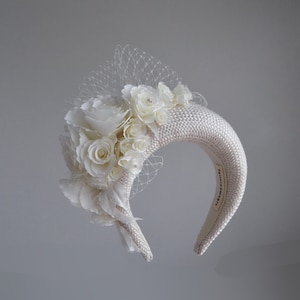 This fascinator for wedding guest  features a floral headpiece. Cream wedding fascinator headband with birdcage veil inspired by Kate Middleton headband hat. Perfect as elegant alternative to traditional wedding guest headband and veil hat for bride.