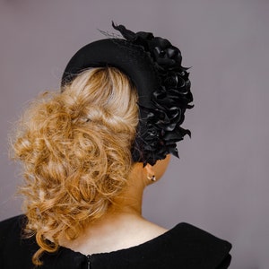 Black fascinator hat for women features a beautiful flower head piece for wedding. Black silk flower crown headband for wedding guest inspired by Kate Middleton headband. Floral headpiece offers alternative to tea party hat and fascinator headband.