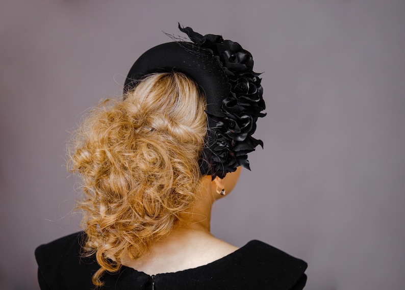 Black fascinator hat for women features a beautiful flower head piece for wedding. Black silk flower crown headband for wedding guest inspired by Kate Middleton headband. Floral headpiece offers alternative to tea party hat and fascinator headband.