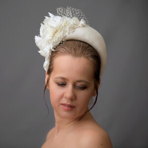 Cream wedding fascinator headband with birdcage veil inspired by Kate Middleton headband hat. Perfect as alternative to a traditional wedding guest headband and church hat. Beige fascinator is hand made. Bridal hairband comes with birdcage veil.
