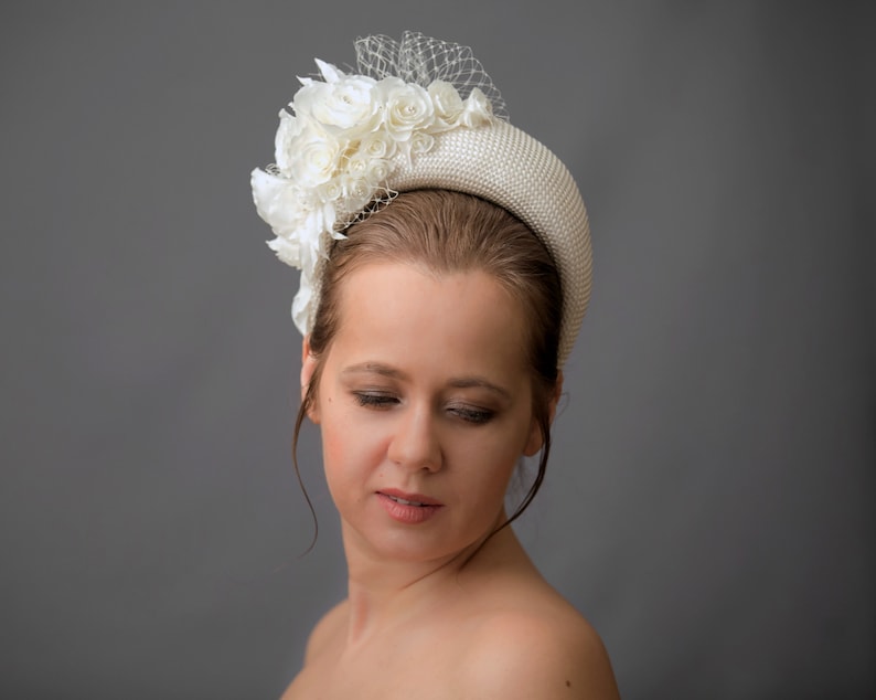 Cream wedding fascinator headband with birdcage veil inspired by Kate Middleton headband hat. Perfect as alternative to a traditional wedding guest headband and church hat. Beige fascinator is hand made. Bridal hairband comes with birdcage veil.