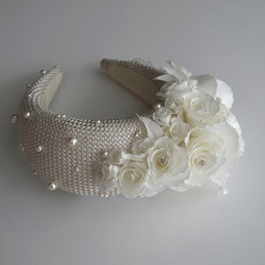 Wide bridal headband with pearls inspired by Kate Middleton.  Bridal flower crown is hand made. Large bridal headpiece comes with multi-sized faux pearls. 
Bridal hairband has been covered in a light ivory fabric trimmed with flowers and leaves.