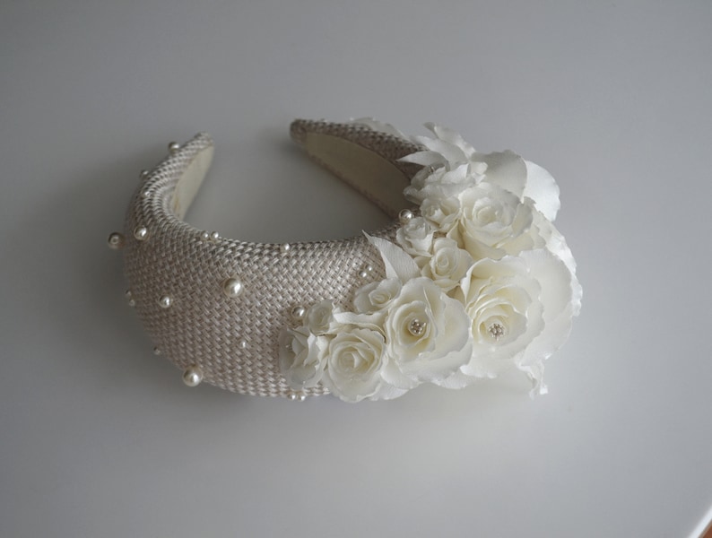 Wide bridal headband with pearls inspired by Kate Middleton.  Bridal flower crown is hand made. Large bridal headpiece comes with multi-sized faux pearls. 
Bridal hairband has been covered in a light ivory fabric trimmed with flowers and leaves.