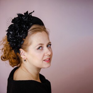 Black fascinator headband for wedding guest is hand made. Black flower crown inspired by Kate Middleton. Padded halo headband comes with birdcage veil or whithout. Beads can be added to the halo headpiece.
Wedding guest hairband trimmed with flowers.