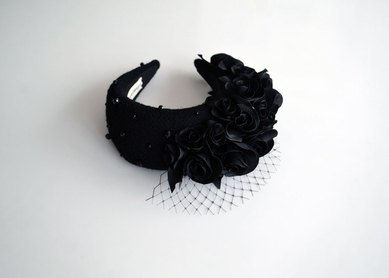 Black fascinator headband for wedding guest is hand made. Black flower crown inspired by Kate Middleton. Padded halo headband comes with birdcage veil or whithout. Beads can be added to the wedding halo hat
Wedding guest hairband trimmed with flowers