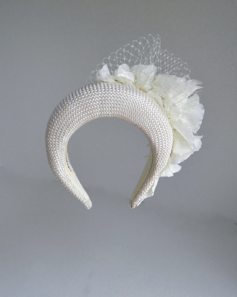 This silk flower headband for wedding features a floral headpiece. Cream wedding fascinator headband with birdcage veil inspired by Kate Middleton headband hat. Perfect as elegant alternative to a traditional wedding guest headband and church hat.