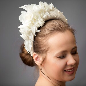 Bridal headband with pearls is hand made. Bidal flower crown comes with multi-sized faux pearls. Bridal hairband has been covered in ivory fabric. Halo crown headband has been trimmed with flowers. Wedding fascinator will instantly elevate any outfit