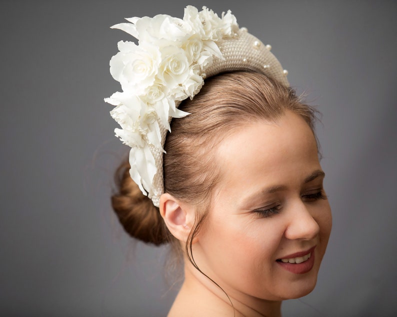 Bridal headband with pearls is hand made. Bidal flower crown comes with multi-sized faux pearls. Bridal hairband has been covered in ivory fabric. Halo crown headband has been trimmed with flowers. Wedding fascinator will instantly elevate any outfit