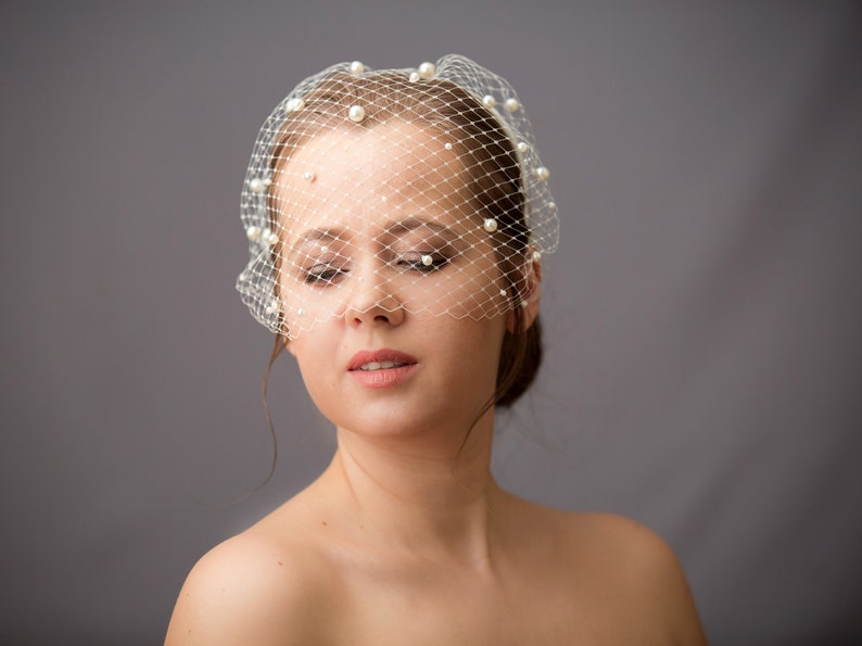 Wedding birdcage veil features with velvet headband and pearls. Bridal hairband with bandeau veil is hand made. Beaded bachelorette veil come with pearls or without.
Headband covered with bird cage veil giving the bridal shower veil a superior finish