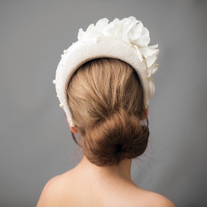 Wide bridal headband with pearls inspired by Kate Middleton.  Bridal flower crown is hand made. Large bridal headpiece comes with multi-sized faux pearls. 
Bridal hairband has been covered in a light ivory fabric trimmed with flowers and leaves.