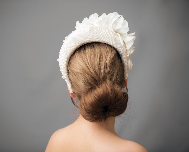 Wide bridal headband with pearls inspired by Kate Middleton.  Bridal flower crown is hand made. Large bridal headpiece comes with multi-sized faux pearls. 
Bridal hairband has been covered in a light ivory fabric trimmed with flowers and leaves.