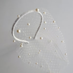 Wedding birdcage blusher veil features with velvet headband and faux pearls. Bridal hairband with pearl bandeau veil is hand made. Bachelorette veil come with a scattering of pearls or without.
Fascinator headband has been covered with bird cage veil