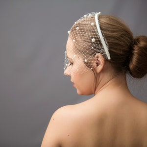 Wedding birdcage blusher veil features with velvet headband and faux pearls. Bridal hairband with pearl bandeau veil is hand made. Bachelorette veil come with a scattering of pearls or without.
Fascinator headband has been covered with bird cage veil