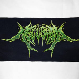 May include: Black rectangular patch with neon green, spiky text. The text appears to be a band logo or design, with a gothic or metal aesthetic. The patch is likely made of fabric and designed to be sewn or ironed onto clothing or accessories.