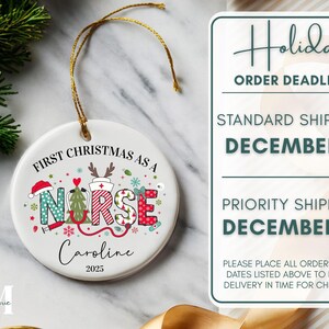 May include: A white ceramic Christmas ornament with a gold string. The ornament features the text "First Christmas as a Nurse" and the name "Caroline" with the year "2025". The word "NURSE" is decorated with festive holiday designs.