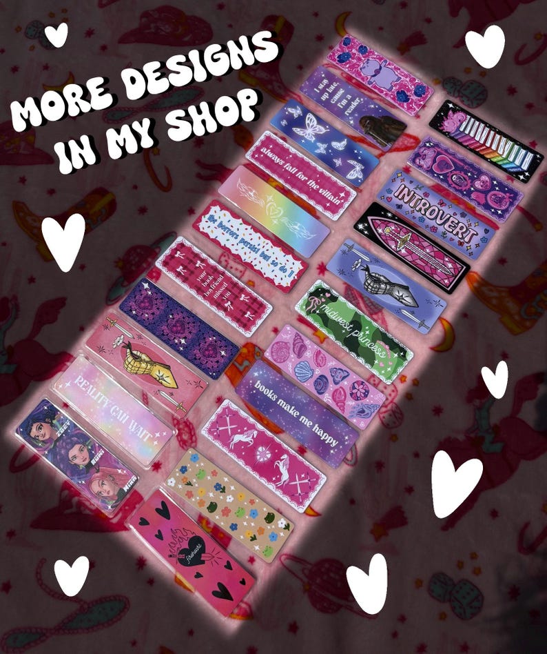 May include: A collection of rectangular bookmarks with various designs and text, including phrases like "always fall for the villain" and "books make me happy." The bookmarks feature colorful patterns, illustrations, and the text "MORE DESIGNS IN MY SHOP."