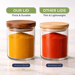 May include: Two clear glass storage jars with lids. The left jar has a dark brown acacia wood lid and contains yellow powder. The right jar has a light bamboo lid and contains red powder. Text reads: OUR LID Thick & Durable, OTHER LIDS Thin & Lightweight.
