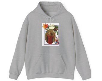 Puede incluir: Una sudadera con capucha gris con un estampado gráfico de una mujer con un vestido rojo sosteniendo un instrumento musical. El gráfico también incluye un bocadillo con el texto "IS YOUR NAME IN THE BOOK OF LIFE?" y flores y estrellas de colores.