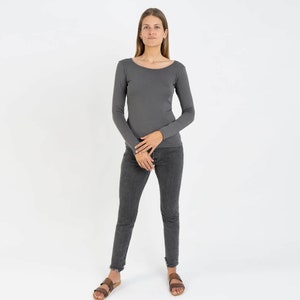 May include: A charcoal gray long-sleeved shirt with a scoop neck. The shirt is fitted and has a casual look.
