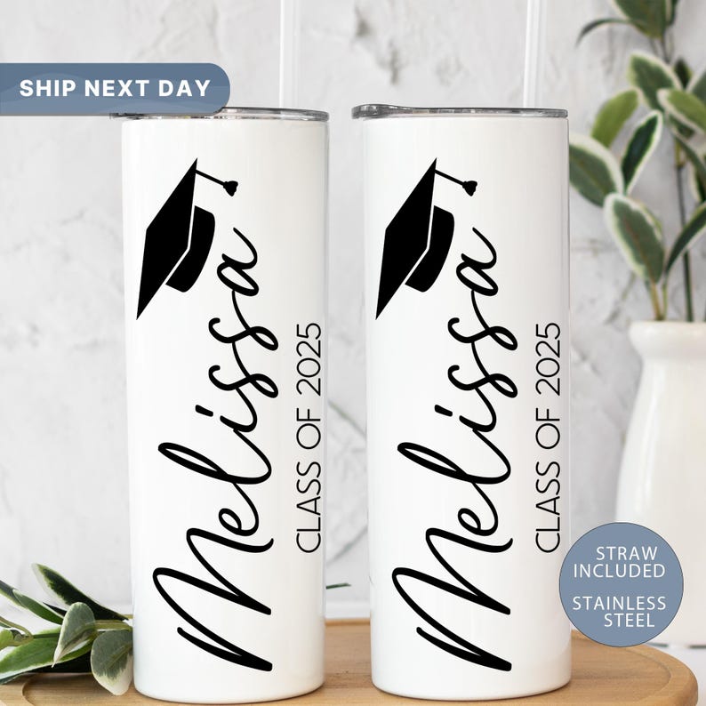 May include: Two white stainless steel tumblers with black text and a graduation cap design. The text on the tumblers reads "Melissa Class of 2025".