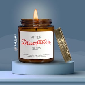 a brown glass jar with a lit candle inside, placed on a blue pedestal against a blue background.