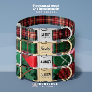 May include: Stacked dog collars with personalized nameplates. The collars feature a variety of plaid patterns in red, green, and black. Each collar has a metal buckle with the name "Buddy" and a phone number.