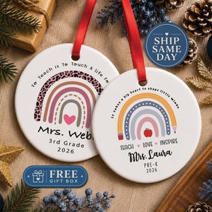 May include: Two round white ceramic ornaments with red ribbon hangers. The left ornament features a leopard print rainbow, a pink heart, and text reading To Teach is To Touch a Life For, Mrs. Webb, 3rd Grade, 2026. The right ornament shows a pencil rainbow, a red apple, and text reading It takes a big heart to shape little minds, TEACH LOVE INSPIRE, Mrs. Laura, PRE-K, 2026.