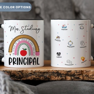 May include: White ceramic coffee mug with a black handle and rim. The mug features a rainbow design with the text "To teach is to touch a life forever" and the word "PRINCIPAL". The mug also has the name "Mrs. Sterling" printed on it. The other side of the mug has a white background with pink and blue hearts and various icons representing teacher qualities.