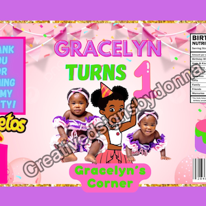 Puede incluir: Una bolsa de regalo de cumpleaños rosa y morada con una imagen de tres niñas y el texto "Gracelyn Turns 1". La bolsa está decorada con purpurina rosa y dorada y tiene el logotipo de Cheeto's en la parte delantera. La parte posterior de la bolsa tiene una etiqueta de información nutricional con el texto "Birthday Nutrition Facts" y una lista de artículos con un valor diario del 1000%.