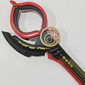 May include: A decorative, stylized weapon with a red and black color scheme. The design features a circular handle, a curved blade, and gold accents. The handle has a red outer ring and a black inner ring. The blade is black with gold detailing.