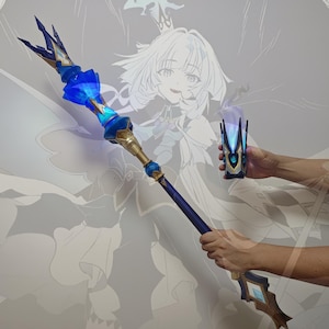 May include: A blue and gold staff with a glowing blue crystal at the top. The staff is held in a person's hands. A smaller, matching object is held in the other hand. The background features a faded illustration of a character.