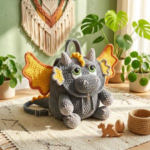 May include: A gray crocheted dragon backpack with yellow and orange wings, green eyes, and a zipper. The dragon is sitting on a cream-colored rug with a wooden dragon toy and a small woven basket.