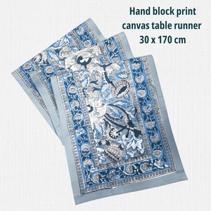 Op de afbeelding: Handblokprint canvas tafelloper met een bloemenpatroon in blauw, wit en grijs. De loper is 30 cm bij 170 cm. De tekst op de afbeelding luidt: Hand block print canvas table runner 30 x 170 cm.