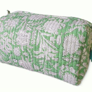 Side view of cute quilted toiletry bags hand block printed with a delicate green & white floral motif. Made of soft organic cotton with internal pockets for small items and a waterproof lining. Uses: Organize toiletries at home or as a travel bag 
Hand block printed by master Artisans in Jaipur, India. The subtle micro variations inherent to hand block printing create a look that cannot be recreated by any other method and ensure that each bag is essentially unique. 

Available in 3 sizes.
