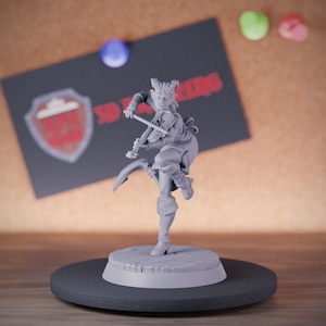 Puede incluir: Una figura en miniatura gris sin pintar de un personaje tiefling con cuernos, de pie sobre una base circular de tablones de madera. La figura está en una pose dinámica, tocando el violín con un arco en la mano, vistiendo botas y ropa.