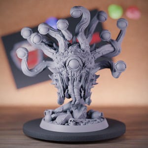Unpainted 3D-printed fantasy beholder miniature, featuring a central eye and multiple eye stalks with intricate detailing. The creature hovers menacingly above a rocky base adorned with skulls, showcasing its fearsome nature. Crafted in high-end UV-cured resin, this model offers exceptional durability and fine detail, perfect for Dungeons & Dragons campaigns. Ideal for painters and collectors seeking a high-quality addition to their tabletop miniatures.