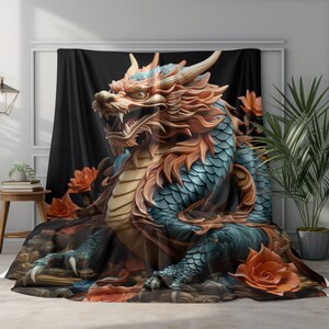 Può includere: Una coperta decorativa con una rappresentazione dettagliata e tridimensionale di un drago cinese. Il drago è prevalentemente blu e arancione, con squame intricate e un'espressione feroce. Fiori arancioni sono sparsi intorno al drago su uno sfondo nero.