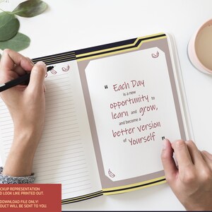May include: A close-up of an open notebook with a quote written in red ink: "Each Day is a new opportunity to learn and grow, and become a better version of Yourself". The notebook has a black and gold border and is open to a page with lined paper. A hand is holding a black pen and writing in the notebook.