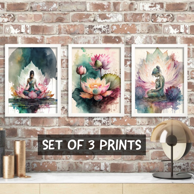 May include: Set of three watercolor prints featuring a woman meditating on a lotus flower, a single lotus flower, and a woman meditating inside a lotus flower. The prints are framed in white and have a watercolor background.