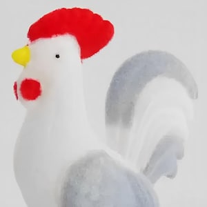 以下が含まれることがあります： 赤い鶏冠、黄色のくちばし、赤い肉髯を持つ装飾的な雄鶏の置物。雄鶏は白い体と灰色のアクセント、黄色の足を持ち、木製の台座の上に立っています。台座には「Made in Portugal」と書かれたラベルが付いています。