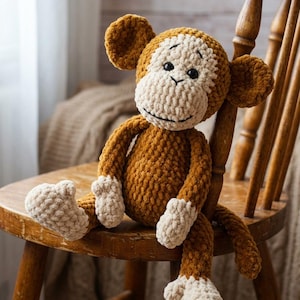 May include: A handmade crochet monkey doll in shades of brown and cream, sitting on a wooden chair. The monkey has a smiling face, large ears, and detailed paws. A cozy, plush toy for children or nursery decor.