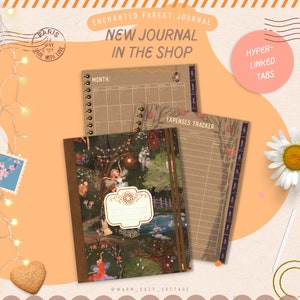 May include: A brown journal with a whimsical forest scene featuring fairies, animals, and lights. The journal has a calendar section, an expenses tracker, and hyper-linked tabs. The text "ENCHANTED FOREST JOURNAL" and "NEW JOURNAL IN THE SHOP" is printed on the cover.