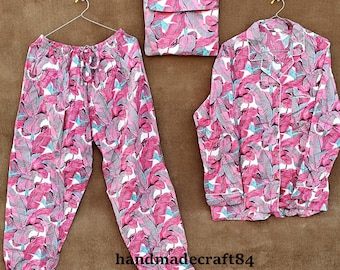 May include: Pink and white pajama set with a leaf print. The set includes a long-sleeved shirt with a button-up front and matching pants.