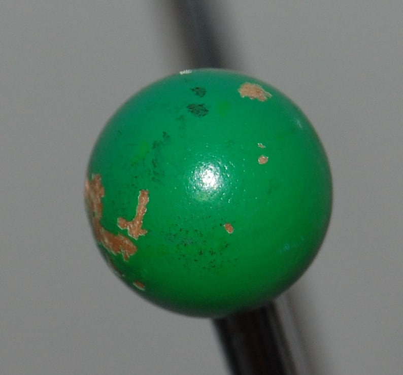 Peut inclure: Une boule verte avec des &eacute;clats de peinture brune et une surface brillante.
