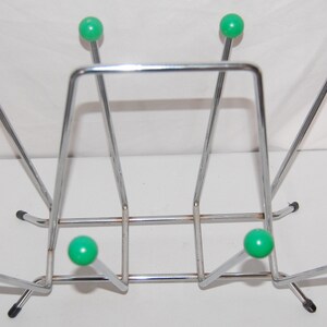 Peut inclure: Un porte-bottes en chrome avec six extr&eacute;mit&eacute;s en forme de boule en plastique vert. Le porte-bottes est con&ccedil;u pour maintenir les bottes debout.