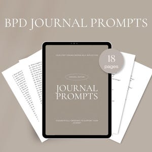 May include: A digital journal with the text "Journal Prompts" on the screen, with the words "Original Edition" and "Thoughtfully Designed to Support Your Journey" below. The journal is surrounded by loose pages with numbered prompts and a circular label that says "18 pages".
