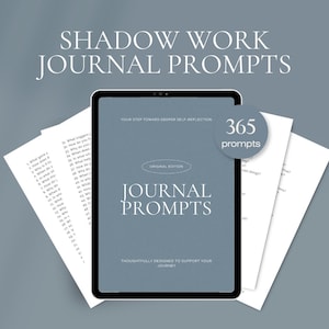 Puede incluir: Un diario digital con el texto "Shadow Work Journal Prompts" y "Journal Prompts" en la pantalla. La pantalla muestra 365 indicaciones para la autorreflexión. Dos hojas de papel con indicaciones están a ambos lados de la tableta.